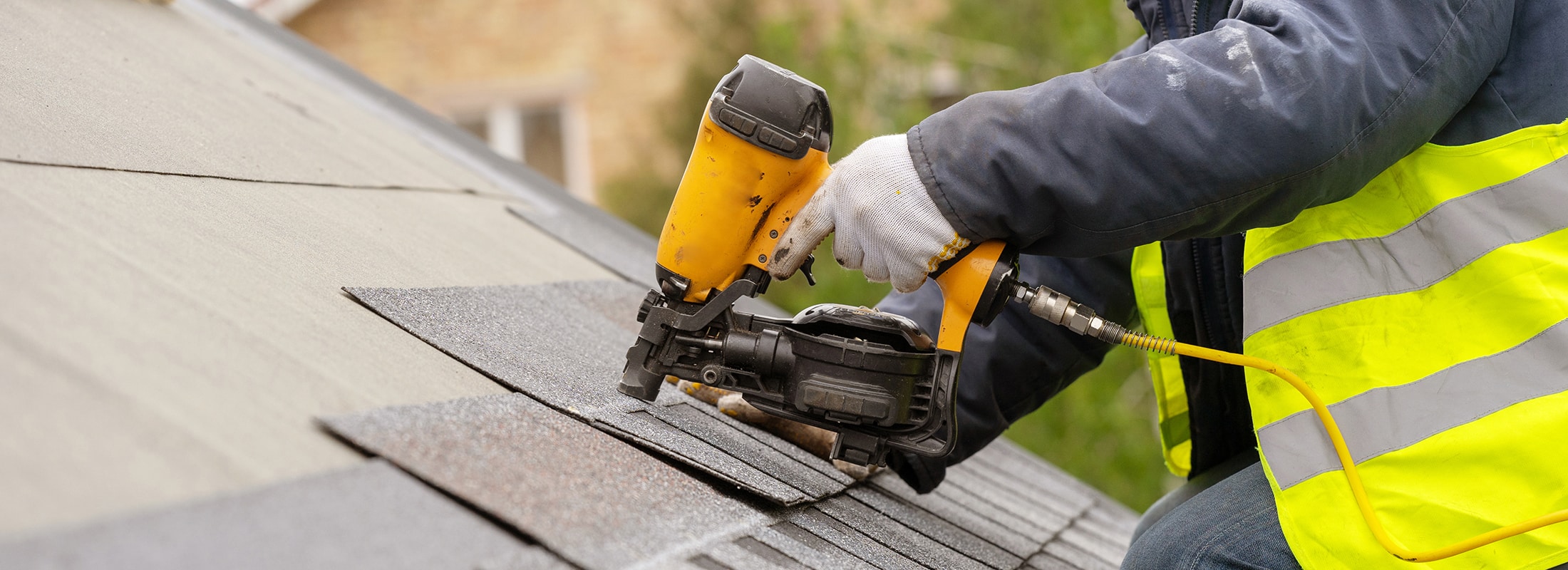Roof Replacement in Nashville, TN 2 Roofer fastening new asphalt shingles with a roofing nailer during a roof replacement