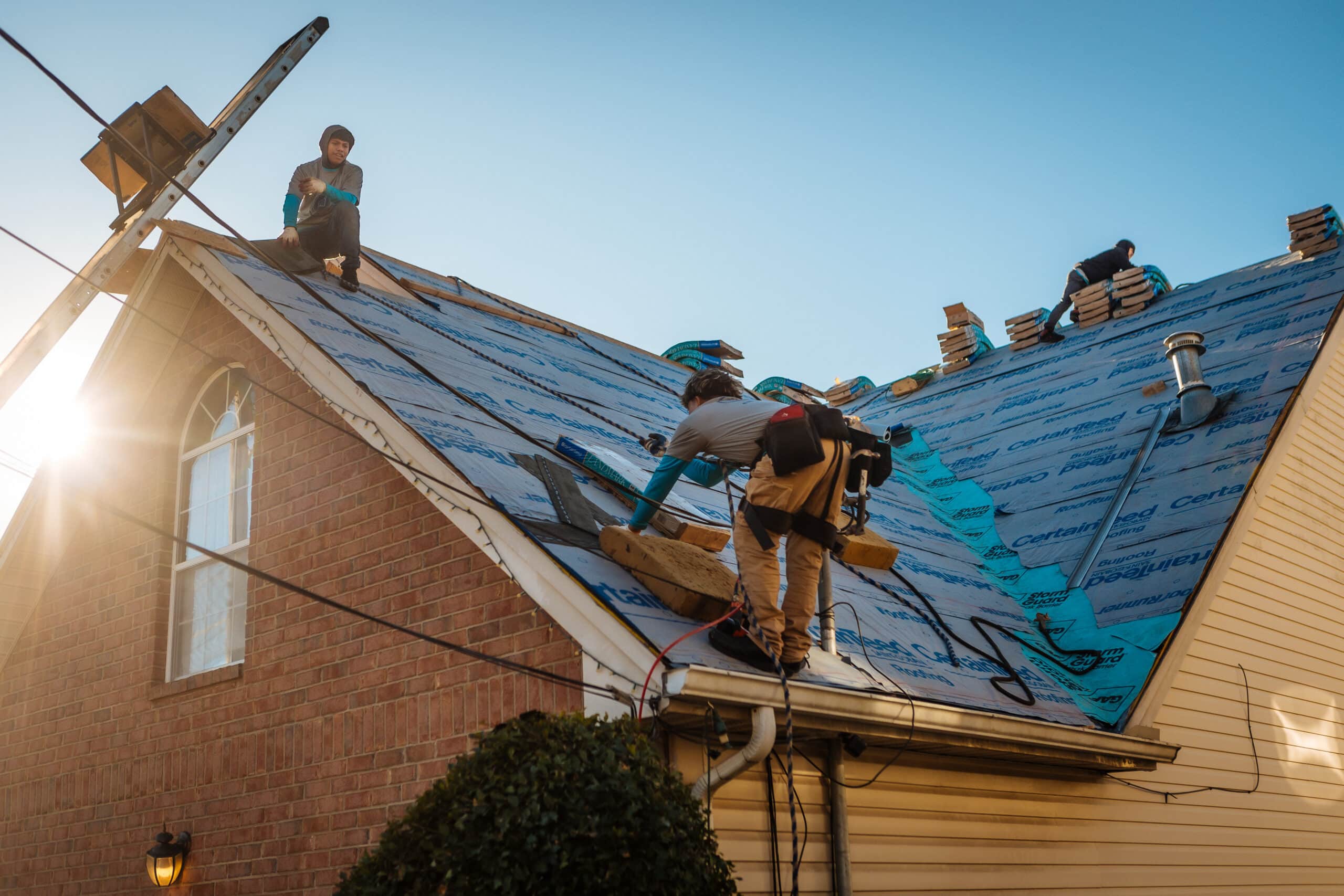 Nashville Roofing Company crew installing underlayment during a full roof replacement in Middle Tennessee, with shingle bundles staged on the ridge