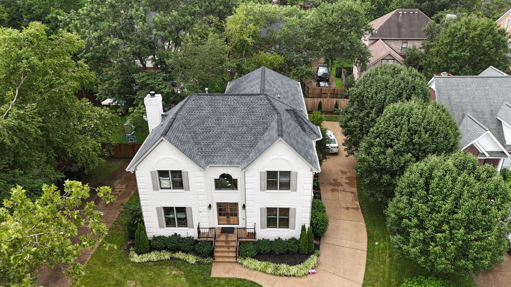 Home 1 Aerial view of a completed gray architectural shingle roof on a white two-story home.