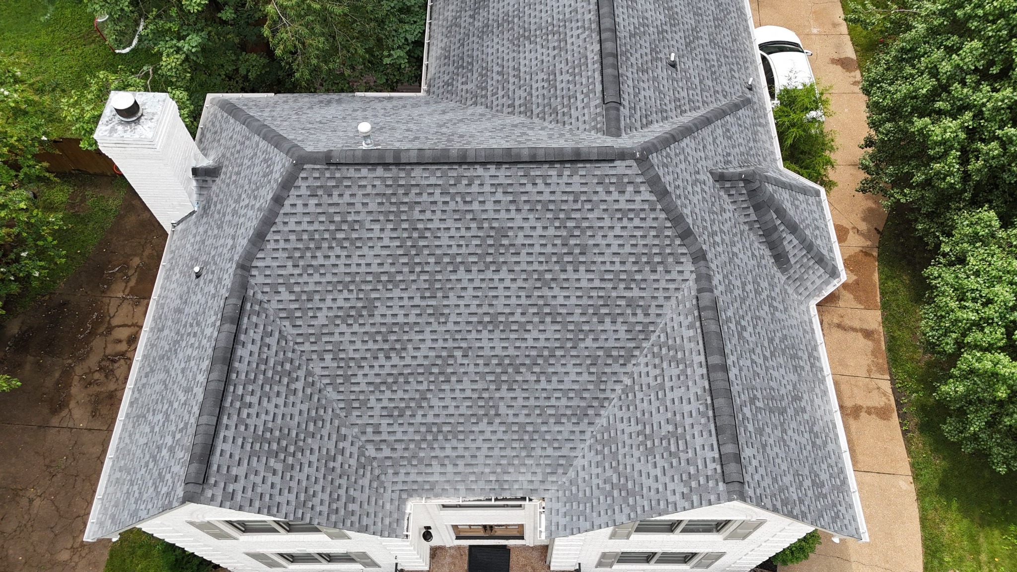 Home 2 Overhead drone view of a completed gray architectural shingle roof with ridge ventilation.
