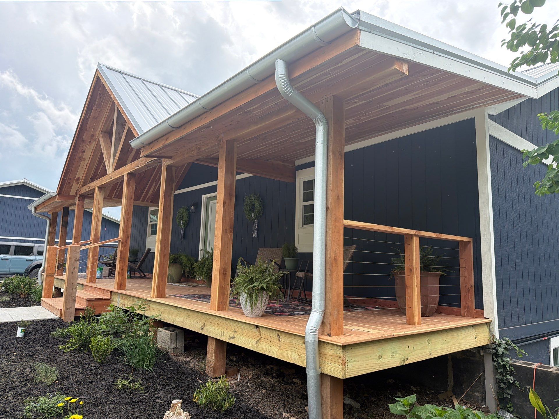 Home 4 Completed cedar porch with a standing-seam metal roof and custom wood details.