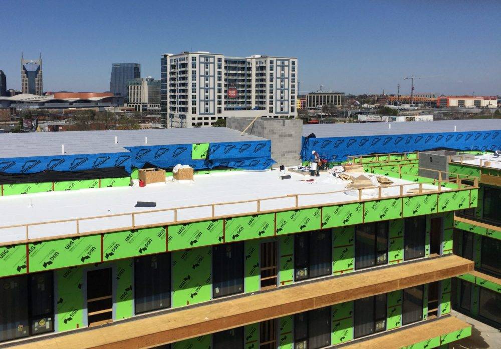 Home 5 Commercial low-slope membrane roof installation on a multi-story building.