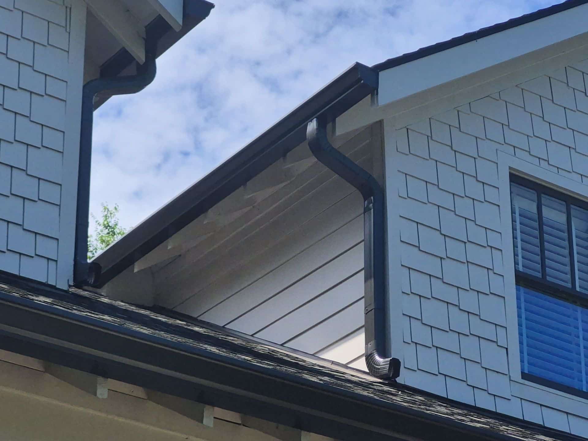 Home 9 Exterior shingle-style siding and black gutter detail on a residential home.
