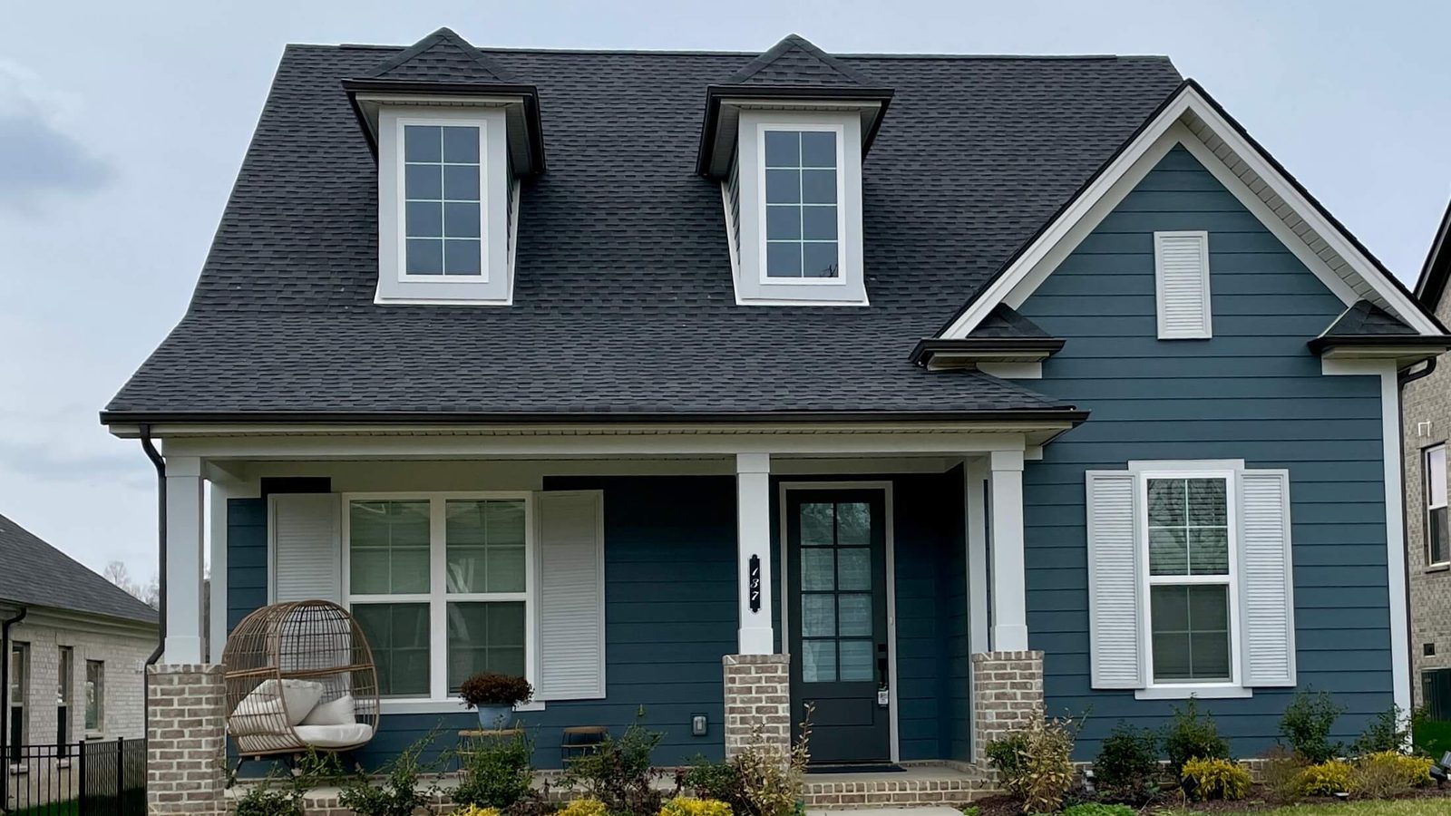 James Hardie Siding in Nashville, TN 1 Slate blue James Hardie lap siding with white trim and brick porch columns on a Nashville area home