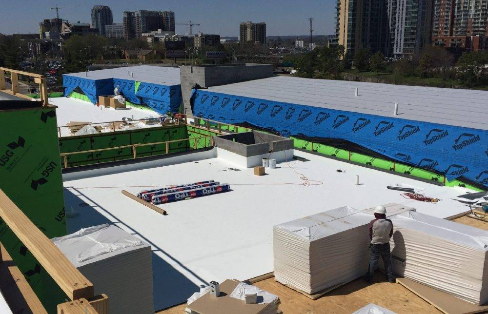 TPO membrane rolls and insulation staged during a commercial low-slope roof installation in Nashville